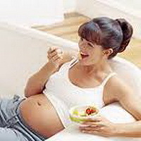 Беременная девушка кушает 