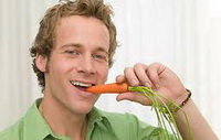 Парень ест морковь и не хочет чтобы на его зубах был пародонтоз