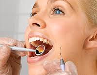 Осмотр стоматолога девушки которая производит профессиональную гигиену зубов 